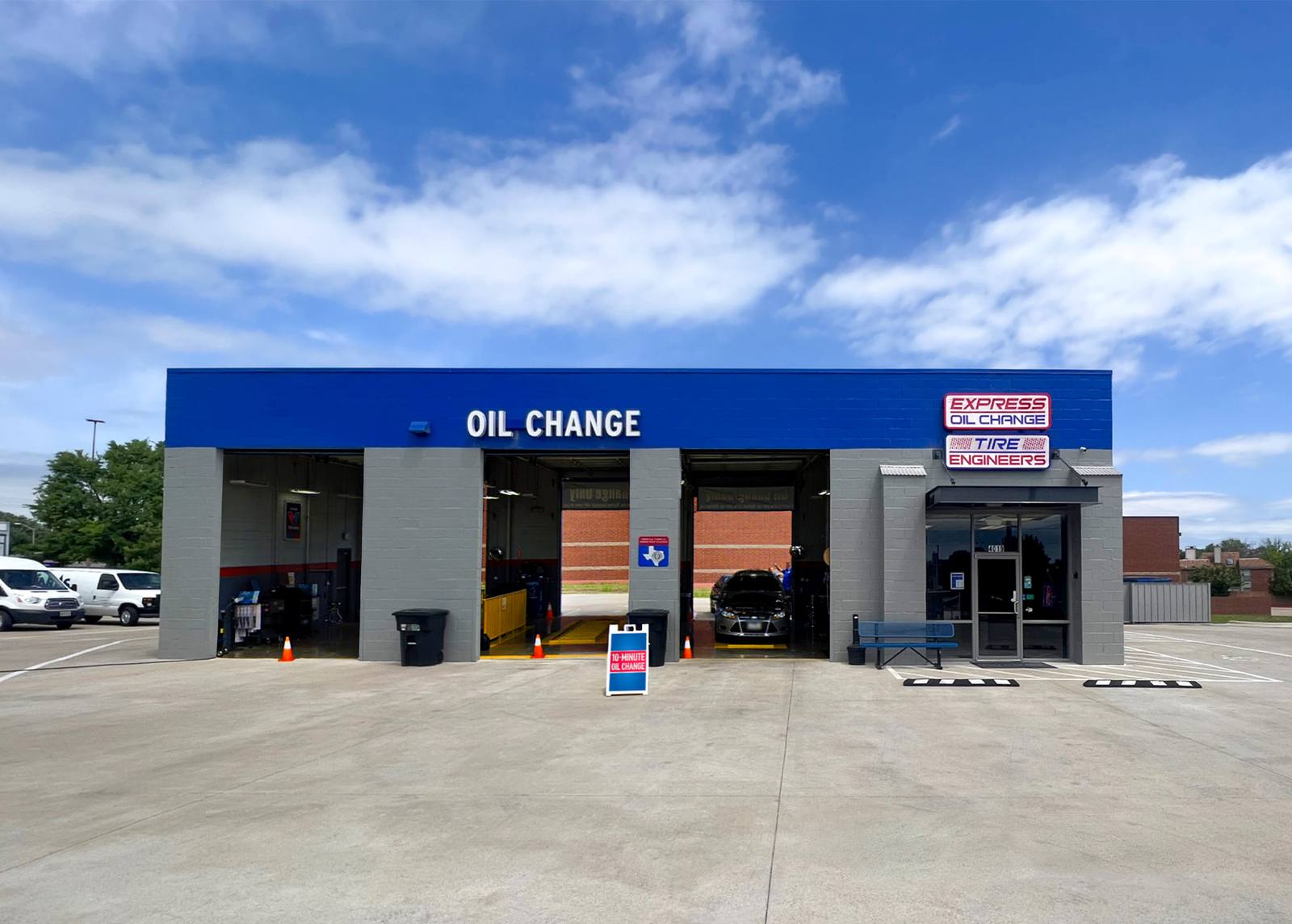 Mobile mechanic draining oil from a car during a driveway oil change
